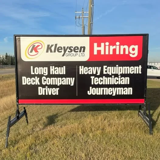 A high-visibility roadside portable sign displayed outside a local retail store
