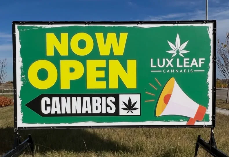 A fresh seasonal promotional banner being updated on a portable sign rental frame.